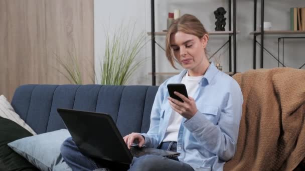 Heureuse jeune femme utilisant un ordinateur portable entrant des informations pour l'achat. — Video