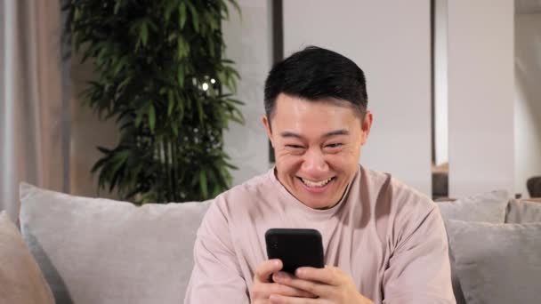 面白い喜びの若いアジアの男の勝者幸せな男性の顧客は成功に興奮 — ストック動画