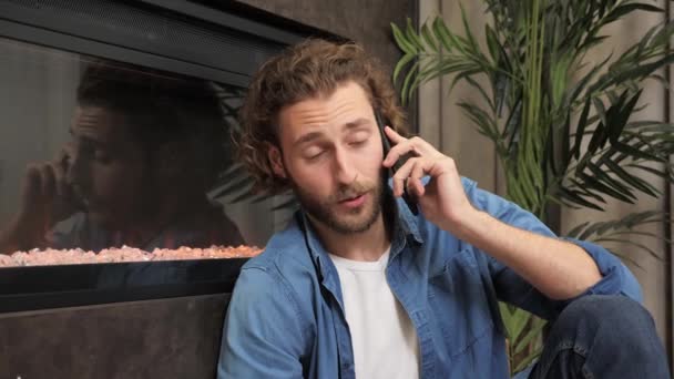 Hombre hablando con un amigo en casa sonrisa en el apartamento moderno usando smartphone. — Vídeo de stock