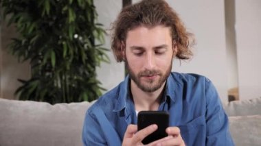 Akıllı telefon kullanan, sosyal medyada gezen, haberleri kontrol eden hoş bir genç adam..
