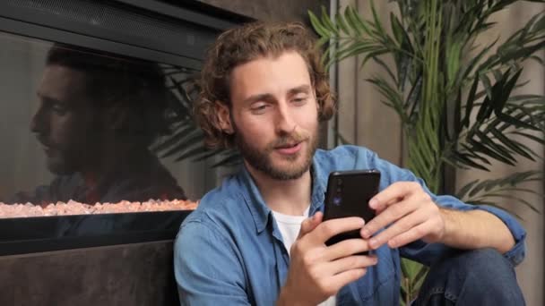 Hombre usando el teléfono cerca de la chimenea video chat comunicación. — Vídeos de Stock