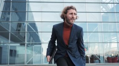 Komik iş adamı dans ederek yeni kariyerini kutluyor ve dizüstü bilgisayarla çalışıyor..