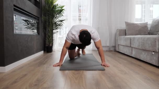 Poderoso asiático hombre de entrenamiento en casa. asiático chico haciendo exprimido desde el suelo. — Vídeo de stock