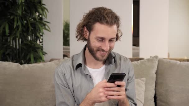 Sonriente hombre sentado en la sala de estar en casa charlando tener una charla con amigos. — Vídeos de Stock