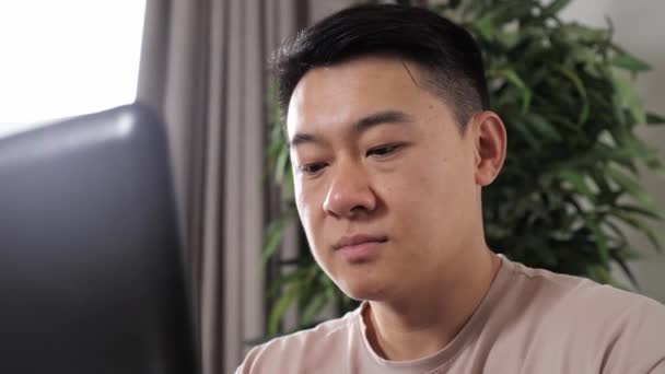 Chinesischer Freiberufler arbeitet zu Hause am Computer. — Stockvideo