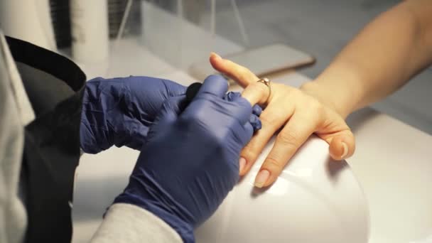 Las manos de la mujer se está haciendo manicura en el salón de uñas. — Vídeo de stock