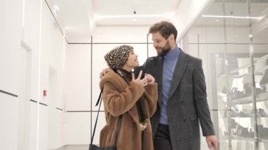 Erkek ve kadın alışveriş merkezinde alışveriş yaptıktan sonra kucaklaşırlar..