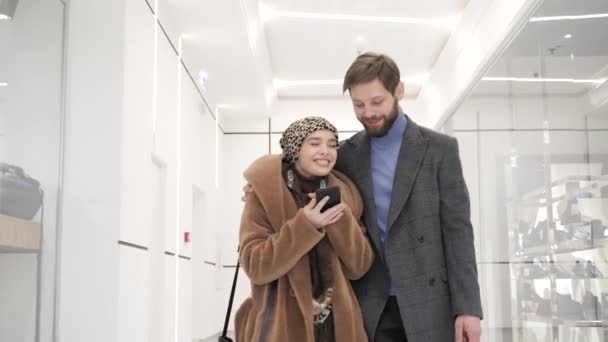 Happy lovely people walking around the mall hugging shopping. — Stockvideo
