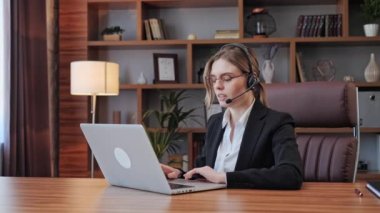 Ofiste çalışan kulaklık takan bir iş kadını uzaktan müşteriye ya da meslektaşına destek oluyor. Arama merkezi, tele pazarlama, müşteri destek acentesi telefon görüşmesinde hizmet sunar.