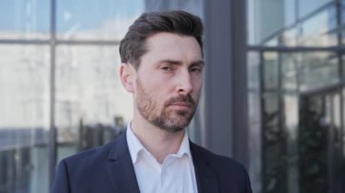 Resmi kıyafet giymiş mutlu odaklanmış bir adamın portresi başını çeviriyor ve dışarıda kameraya bakıyor. Sakallı bir adam kendine güveniyor. Pozitif yüz duygularına kapan iş adamı başarılı insanlar.
