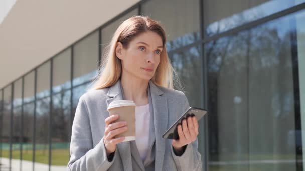 Close up focused businesswoman using phone at street. Serious business woman standing with phone and coffee outdoor. Adult woman messaging on phone. Female entrepreneur working with smartphone online. — 비디오