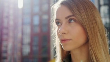 Düz Yüzlü Sarışın Kız 'ın Mavi Gözler Güzel Dudaklar' ını açarken yakın görüntüsü. Doğal Güzellik Çocuğu Görünümü. Uzun kirpikli kadın, Düşünceli Şehir Arkaplanı. Yavaş çekim.