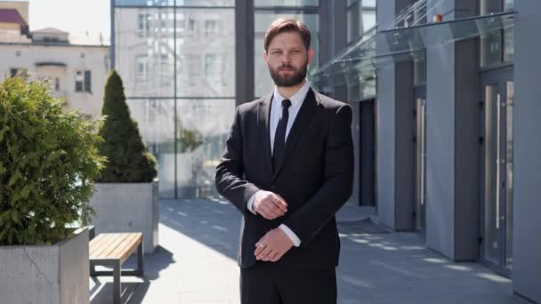 Portret van een succesvolle zakenman in Standing Near Office Center in Modern Business District. Man draait hoofd naar de camera, kruisen armen, Charmant glimlachen en staking een neus buiten. — Stockvideo