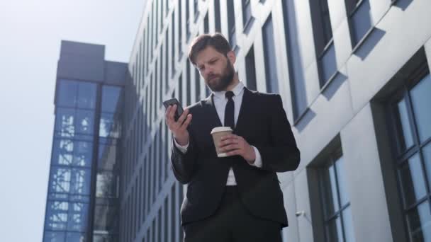 Empresário feliz se divertindo celebrando a vitória em um vencedor do telefone móvel. Jovem profissional urbano, empresário bem sucedido atingindo metas pessoais. Aplicativo conceito para smartphone ou videogame online. — Vídeo de Stock