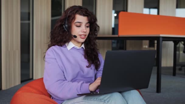 Pretty business woman freelancer wearing headset working in office to support remote customer. Call center, telemarketing, customer support agent provide service on telephone video conference call. — Stok video