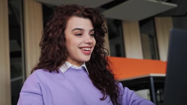 Close up view of smiling happy young woman school college student wearing violet sweater learning watching online webinar webcast looking at laptop distance course or video calling teacher by webcam. — Stockvideo