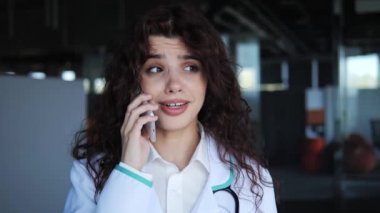 Kıvırcık saçlı, doktor bozuntusu, cep telefonuyla konuşan, uzaktan kumandalı kadın terapiste danışan, tedavi amaçlı mobil sohbeti tartışan güzel bir kadın cerrah..