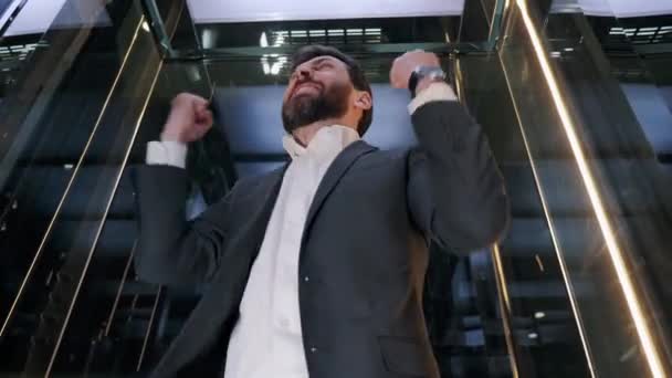 Hombre de negocios estresado subiendo de la oficina en un elevador de vidrio en el moderno centro de negocios. Especialista devastado sintiéndose enojado después de fracasado proyecto de reunión de negocios mal día, Gerente nervioso. — Vídeos de Stock