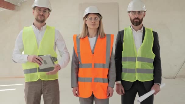 Portrait de travailleuse industrielle indienne sur le chantier de construction.Travailleuse industrielle asiatique regardant la caméra portant un gilet haut de gamme et un casque ou un cache-oreilles avec croisement des mains. — Video