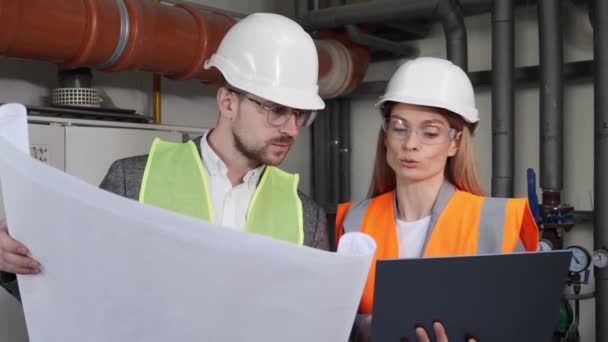 Engineer planning work builders using blueprints and laptop. Building industry Architecture. Business teamwork concept. Workers Professional at the factory as a team discuss water supply system. — Vídeos de Stock