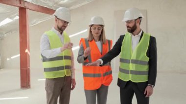 Anlaşmanın sembolü mühendislerin başarılı çalışmaları. Grup teknoloji işçileri yeni inşa edilmiş bir aparthotel ya da iş merkezinde gülümsüyor ellerini birleştiriyor, çalışanları birleştiriyor ortak iş yapıyorlar..