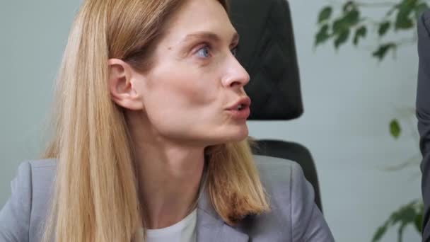 Confident young female boss corporate leader manager counselor communicate with office worker business professional team. Businesswoman sitting at desk working discussing project together. — Vídeo de Stock