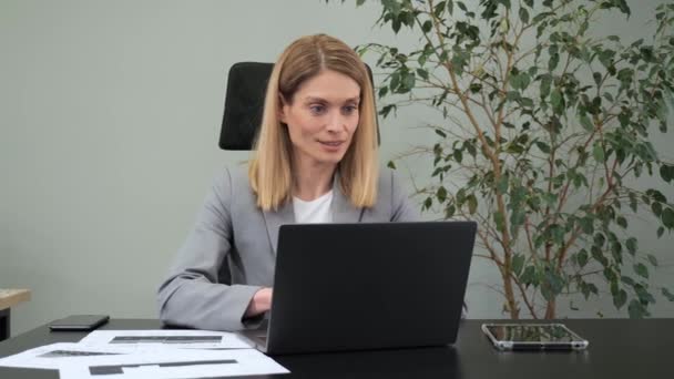 Сосредоточенный энтузиазм деловой женщины, работающей на ноутбуке в офисе. Женщина-менеджер печатает на клавиатуре ноутбука в помещении. Портрет серьезной деловой женщины, смотрящей на экран ноутбука. — стоковое видео