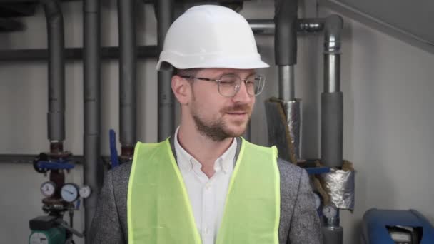 Close up face of smiling talented male architect in eyeglasses standing near water supply systems. Busy concentrated adult man engineer looking at camera positive. Professional Engineering. — Vídeo de Stock