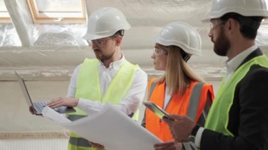 Profesyonel Uzman Ekibi inşaat alanında dizüstü bilgisayar kullanıyor. İnşaat Mühendisi, Mimari Yatırımcı, İş Kadını ve İşçi Planı ile Emlak Boş Bina Projesi.