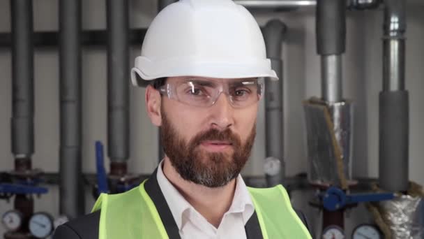 Hard Hat veya Safety Ear 'daki Kendine Güvenen Profesyonel Müteahhit Portresi veya Üniforma Giyen Mühendis İşçi Üniforması, Kazan Odasında Gözlük. Erkek Nitelikli Uzman Su Borularının Yanında Duruyor. — Stok video