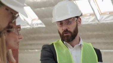 Profesyonel mühendisler ve iş adamlarından oluşan bir ekip gayrimenkul satın almayı tartışıyor, plandaki planı tartışıyor. İnsanlar bina tasarımı hakkında iletişim kurarlar. Başarılı Erkek Uzmanı.