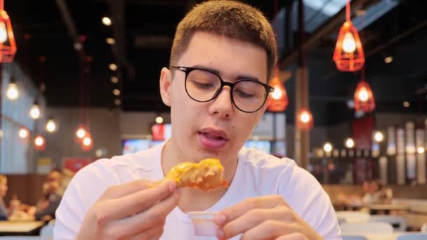 Смешной Привлекательный Парень Белой Рубашке Очках Ест Жареную Курицу Аппетитностью — стоковое видео