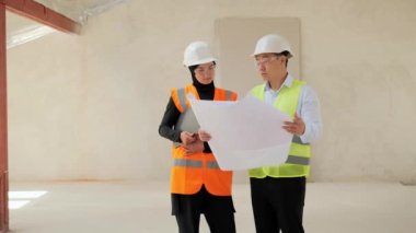 Asyalı erkek emlakçı, Müslüman Arap iş kadını için boş modern dairenin planını gösteriyor. Çinli bir mühendis, Kiralama ile ilgili bir otel ya da apartman projesi planı gösterir