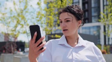 Şehir Caddesinde dikilirken, Akıllı Kıyafetli Güzel Yetişkin Bir Kadın Esmer 'in Arkadaşlarıyla ya da İş Arkadaşlarıyla Konuşurken Görüntü Aranıyor. Büyüleyici İş Kadını Dışarıda