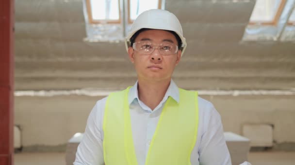 韩国建筑师肖像画 中国亚洲专业地产代理商人头戴硬礼帽手持蓝图看着相机 在室内制造工厂 对工人进行检查 — 图库视频影像
