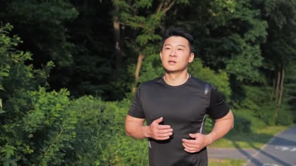 日本のスポーツマンJog Cardio Workout マラソン競技前のランナーのフィットネスハードトレーニング 男性フィットネスの練習を実行します トライアスロンの日没時間を準備公園でアスリートジョギング — ストック動画