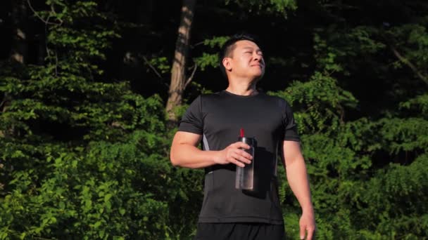 Athletic Uomo Coreano Possesso Una Bottiglia Acqua Trova Nel Parco — Video Stock