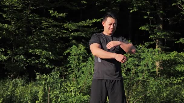 Pelari Asia Yang Kuat Merentangkan Tangan Sebelum Berlatih Taman Musim — Stok Video
