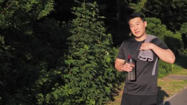 Gelukkig Aziatisch Man Met Een Handdoek Zijn Schouder Wandelen Zomerpark — Stockvideo
