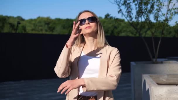 Das Porträt Einer Jungen Blonden Frau Mit Sonnenbrille Steht Draußen — Stockvideo