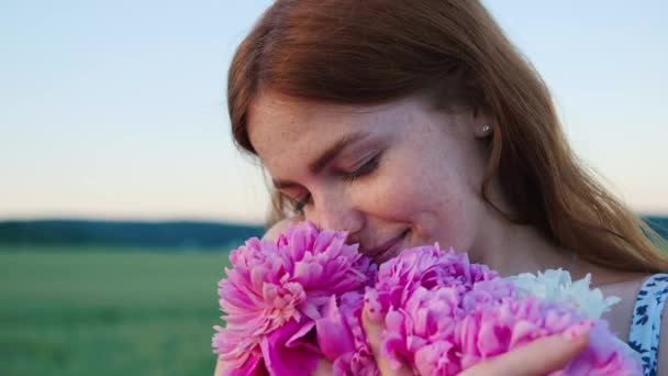 Urocza Twarz Pięknej Rudej Dziewczyny Piegami Kobieta Trzymająca Różowe Kwiaty — Wideo stockowe