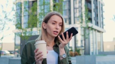 Akıllı telefonda ses tanıma kullanan sarışın kız düşünceleri, sesli arama mesajını, hoparlörden konuşmayı ya da ofis merkezinin yakınındaki sesli sanal mobil uygulamayı dikte eder.