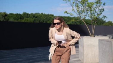 Güneş gözlüklü bir iş kadını midesi ağrıyan seyyar bir araba tutuyor dışarıda duruyor, karnını tutuyor, sabahları karın ağrısı ya da adet sancısı çekiyor. Gastrit ishal ve acı dolu dönem konsepti.