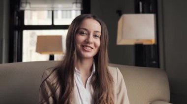 Yumuşak koltukta oturan iş kadını lobide görüntülü sohbet konferansı istiyor.