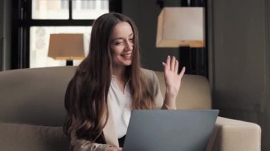 Otel odasında internetten bilgisayarını kullanan mutlu bir iş kadını.