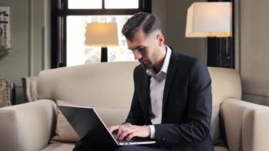Focused businessman working on laptop computer at lobby hotel
