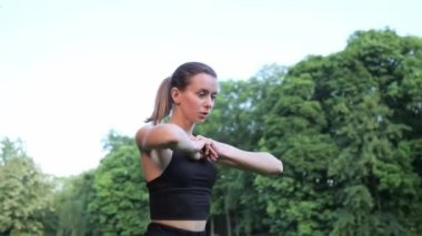 Gecekondu Gölü 'nde egzersiz yapan güzel atletik genç bir kadın spor kıyafetli zayıf bir bayan şehir parkında spor yapıyor. Katlanmış Elleri Açık Çömelmiş Kız