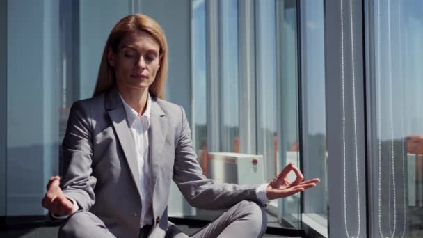 Klasik Gri Takım Elbiseli Yorgun Kadını Lotus Pozisyonunda Meditasyon Yapıyor — Stok video
