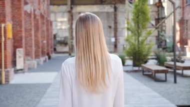 Beyaz tişörtlü güzel sarışın kadının şehir sokaklarında güvenle yürüdüğünü ve kamerada beni takip ettiğini görüyorum. Güzel bir gülüşü, harika bir cildi var.