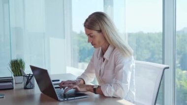 Happy businesswoman finish working on laptop, put hands behind head lean on comfy office chair for productive workday near panoramic window, good posture. Fruitful work accomplishment concept